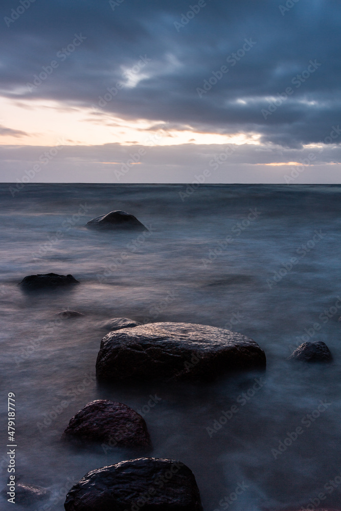 Baltic Sea rocks and beach sand at sunset