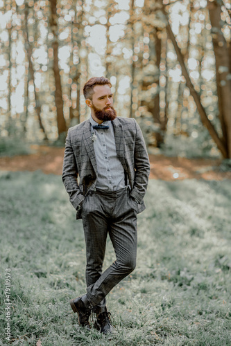 Handsome bearded groom in the Park. Wedding on the nature.