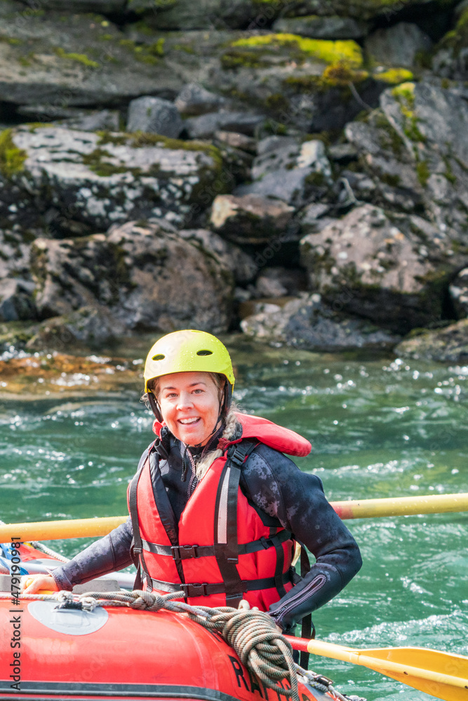 Obraz premium Water sport portrait of smiling happy girl in river raft. Extreme sports and happiness concept.