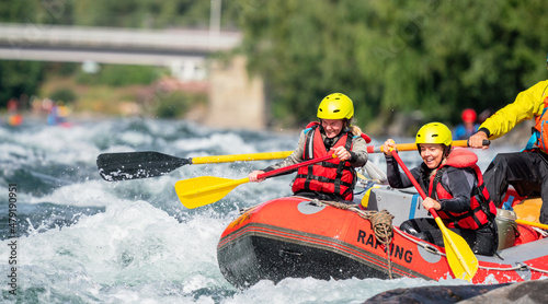 Two girls enjoying themself with river rafting water sports. Smiles, recreation and happiness concept. Removed logos.