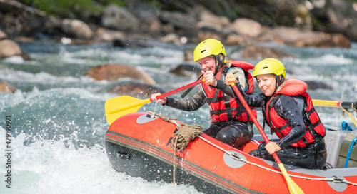 Two girls enjoying themself with river rafting water sports. Smiles, recreation and happiness concept. Removed logos.
