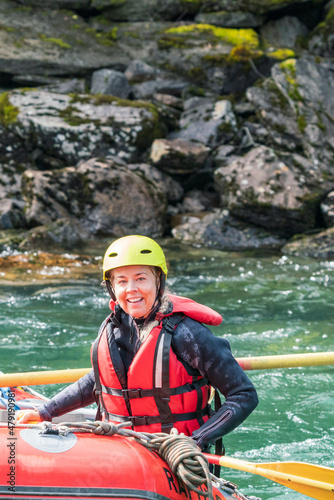 Water sport portrait of smiling happy girl in river raft. Extreme sports and happiness concept.