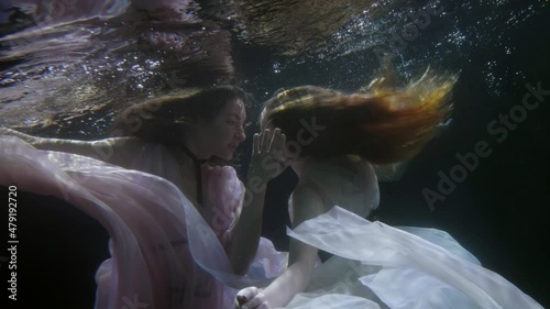 bisexual or homosexual women are swimming underwater, romantic and sensual lesbians