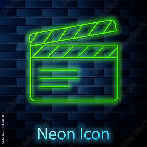 Glowing neon line Movie clapper icon isolated on brick wall background. Film clapper board. Clapperboard sign. Cinema production or media industry. Vector