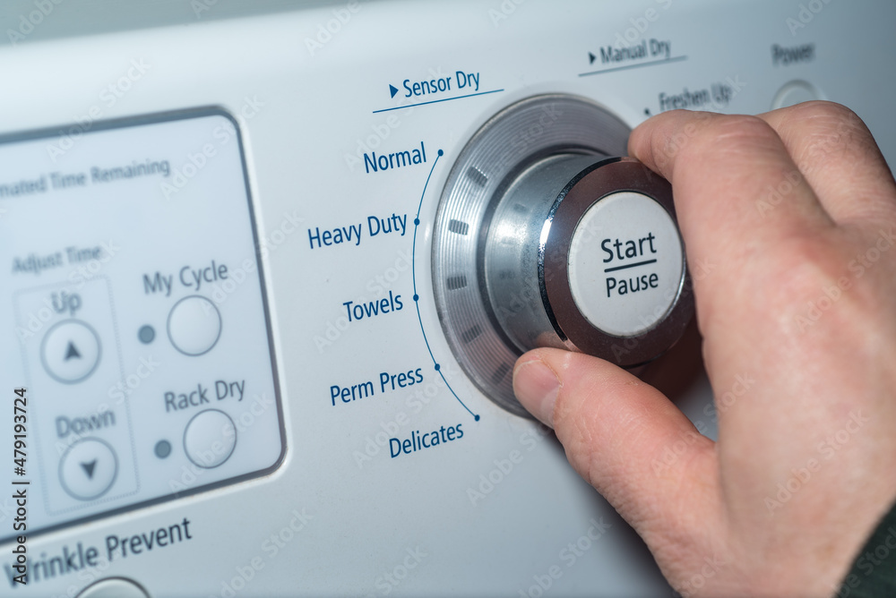 Hand turning the knob of the dryer to adjust the setting. Hand turning the knob of the dryer to adjust the setting.