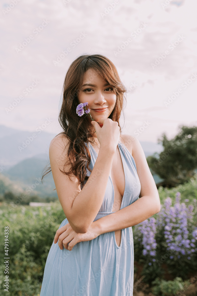 Portrait of thai young woman enjoying in blooming flower field Portrait of thai young woman enjoying in blooming flower field