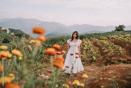 Portrait of thai young woman enjoying in blooming flower field photo