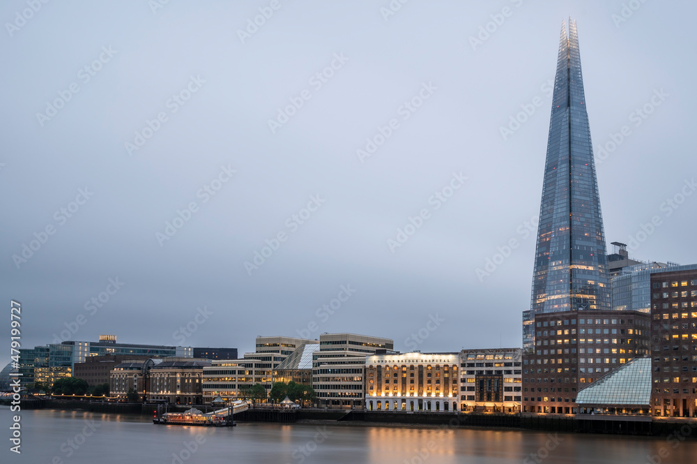 London skyline, lit up at night, with the lights reflecting on the smooth water of the river Thames London skyline, lit up at night, with the lights reflecting on the smooth water of the river Thames