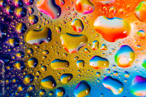 Water droplets on a glass in form of lenses with a colourful background. Wallpaper for screen. Abstract background.