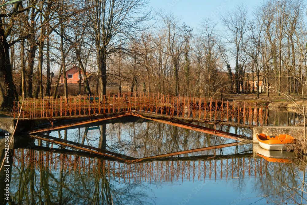 Calm and tranquil nature scene - peaceful lake and tree reflection in the park of old abandoned castle near Vrsac, Vojvodina