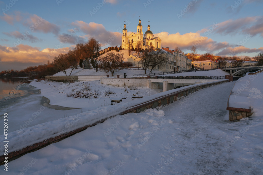 View of the Vitba River embankment, Holy Spirit Convent and Holy Assumption Cathedral on a winter evening, Vitebsk, Belarus