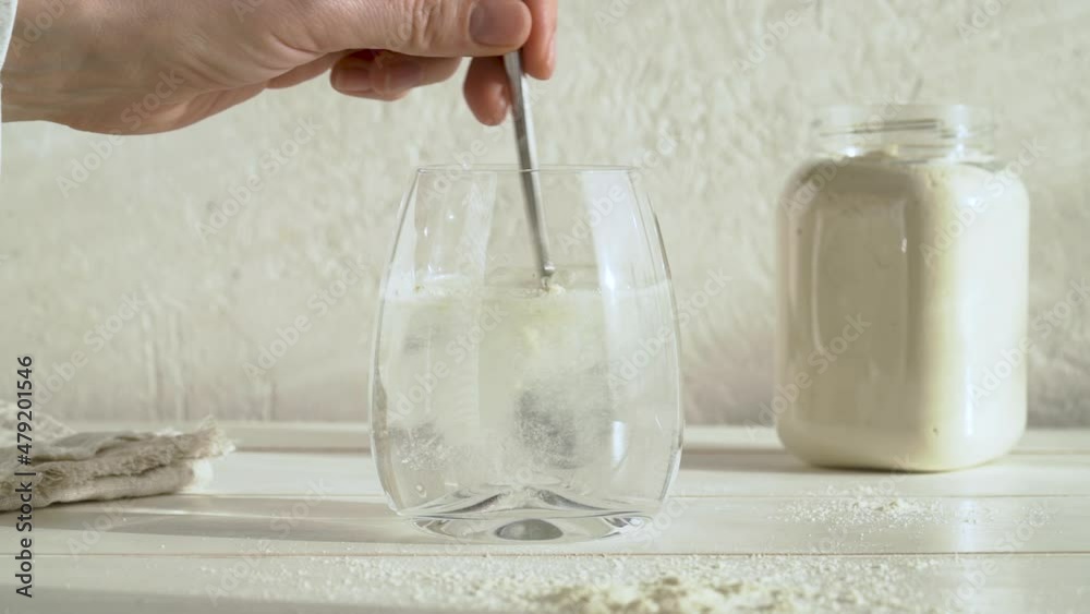 Putting a teaspoon of whey protein powder into a glass of water and stirring it, slow motion Putting a teaspoon of whey protein powder into a glass of water and stirring it, slow motion
