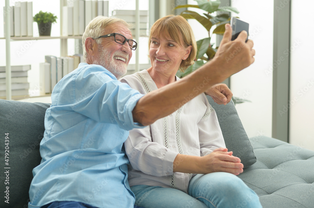 Fototapeta premium Caucasian happy seniors elderly are video calling to family or friends, relax at home, smiling healthy senior retired grandparents, older grandparent technology concept