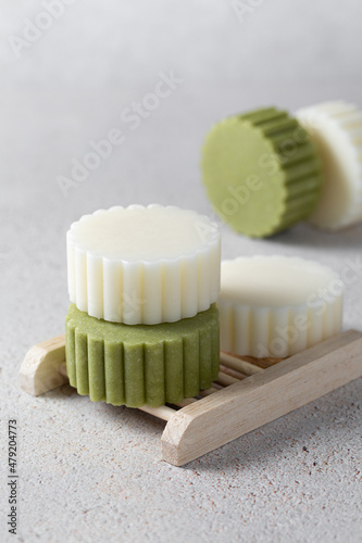 Eco friendly solid handmade colorful shampoo and conditioner bars on light colored background