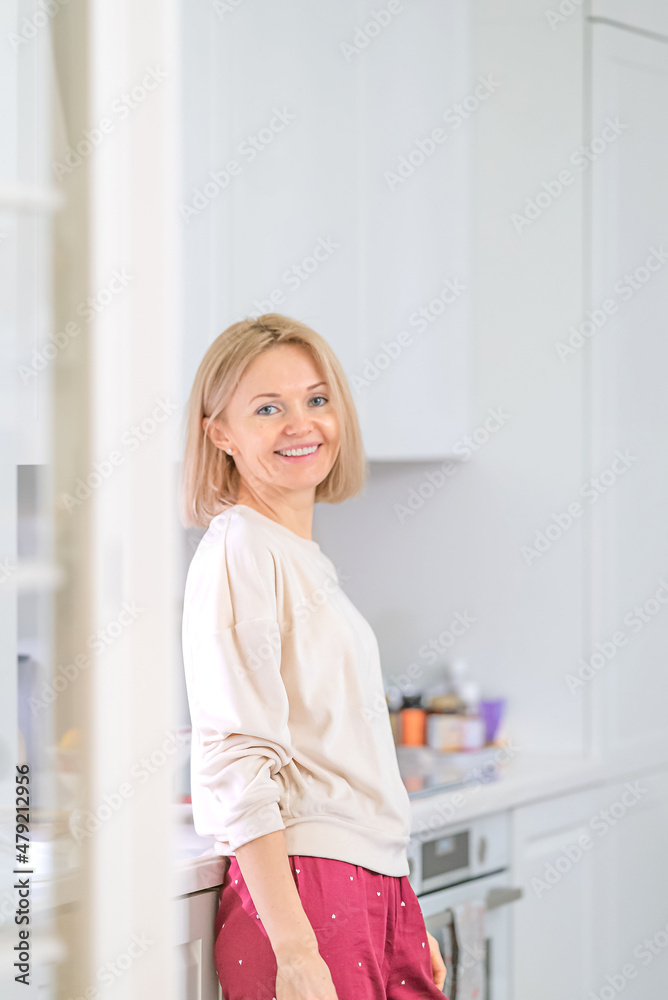 Young beautiful blonde girl at home in the kitchen