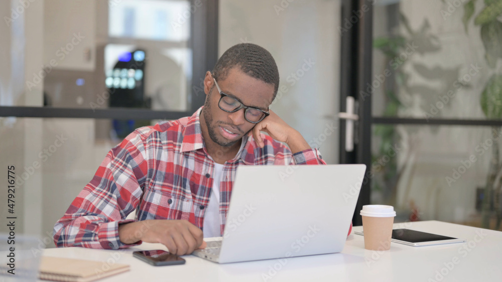 Tired African Man Sleeping While Sitting in Office with Laptop Tired African Man Sleeping While Sitting in Office with Laptop