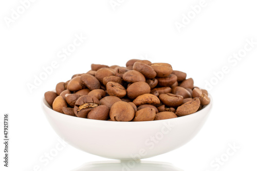 Several fragrant freshly roasted coffee beans with a white ceramic saucer, close-up, isolated on white. © Oleksandr