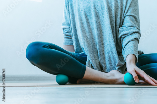 Person doing yin yoga and myofascial release on base of palm and shin muscle. Concept: self-care practices at home, SMFR, myoyin photo