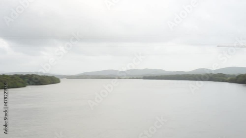 HD scenery of the Zuari river flowing through Borim village in Goa India with a view of a shipbuilding company and Borim Bridge photo