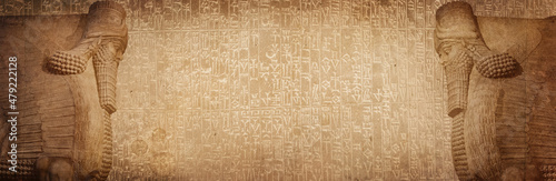 Fotografia Ancient cuneiform Sumerian text and winged statue of Lamassu, a mythical Assyrian deity