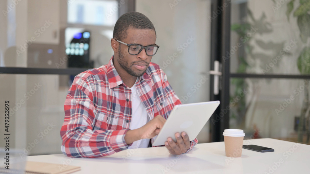 African Man using Tablet while Sitting in Office African Man using Tablet while Sitting in Office