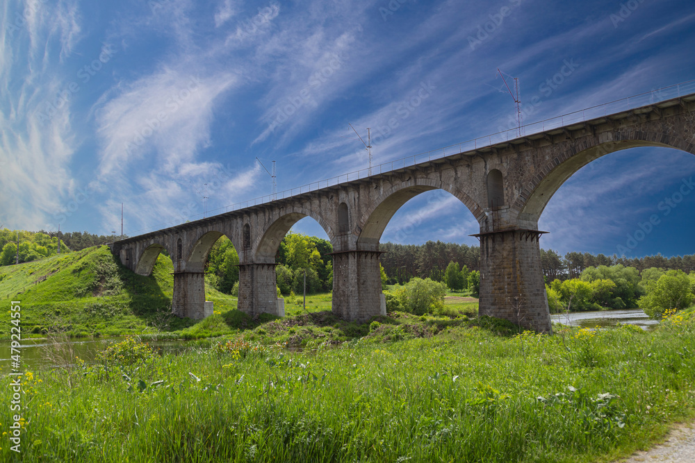 Viaduct. Beautiful old arched stone railway bridge against the backdrop of a scenic landscape