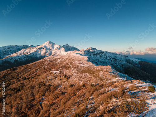 Aerial view of a ridge at the Col de Battaglia leading towards the snow covered peak of Monte San Parteo in the Balagne region of Corsica photo