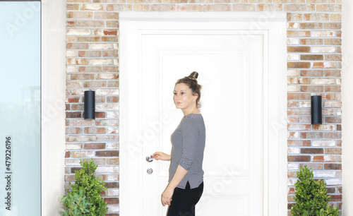 Beautiful woman opening the door of her home.