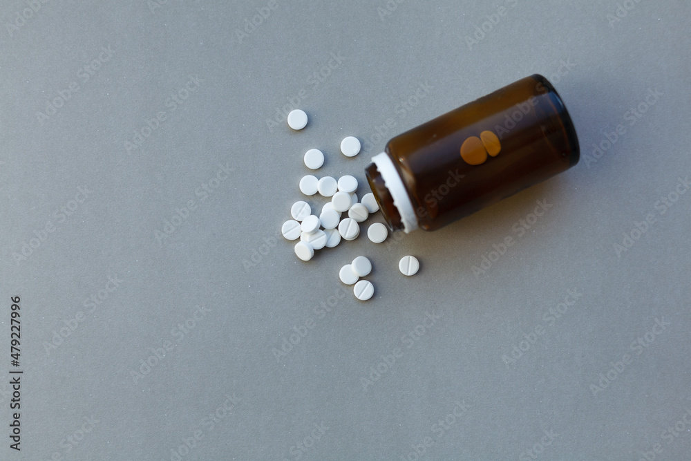 White pills (medicine) spilling out of a brown bottle - obrazy, fototapety, plakaty 