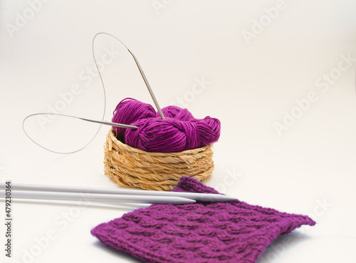 Balls of colored knitting threads and knitting needles on a white background. Needlework and stress relief