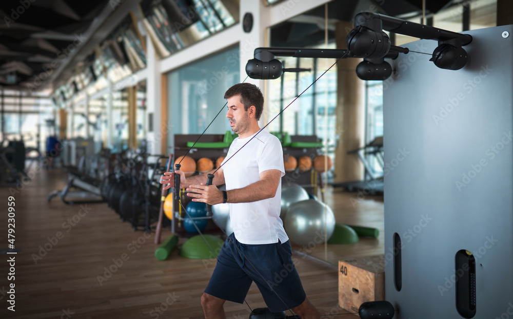 Fototapeta premium Man exercising in the gym on a pec deck machine for chest workout