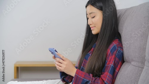 Beautiful young asian woman using mobile phone. Girl from Vietnam communicating online on social media app. Vietnamese female typing message on cellphone. BIPOC person lifestyle video