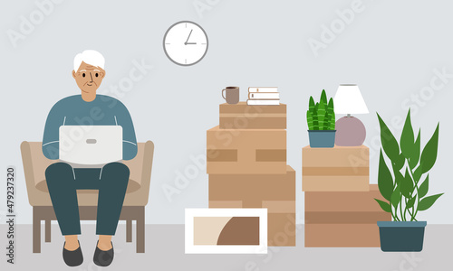 Grandfather at home with a laptop sits in a chair. The concept of online registration of delivery of boxes, goods and assistance in moving.