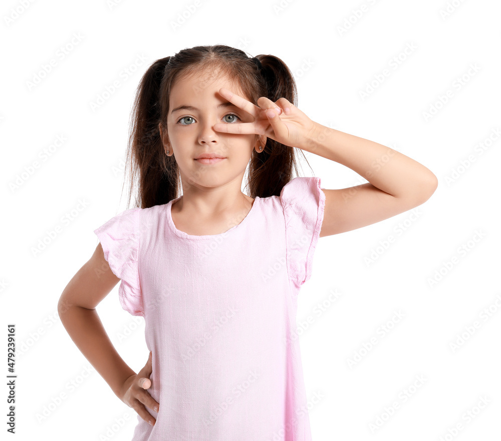 Adorable little girl in pink dress showing victory gesture on white background Adorable little girl in pink dress showing victory gesture on white background