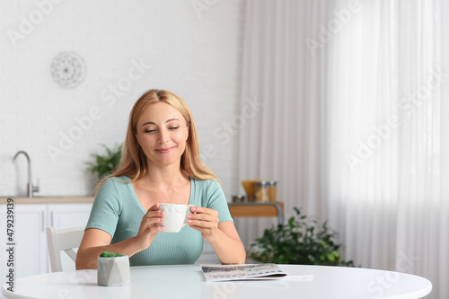 Beautiful mature woman drinking coffee at home