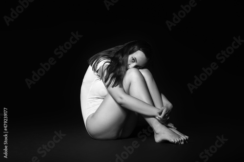 Scared young woman on dark ...