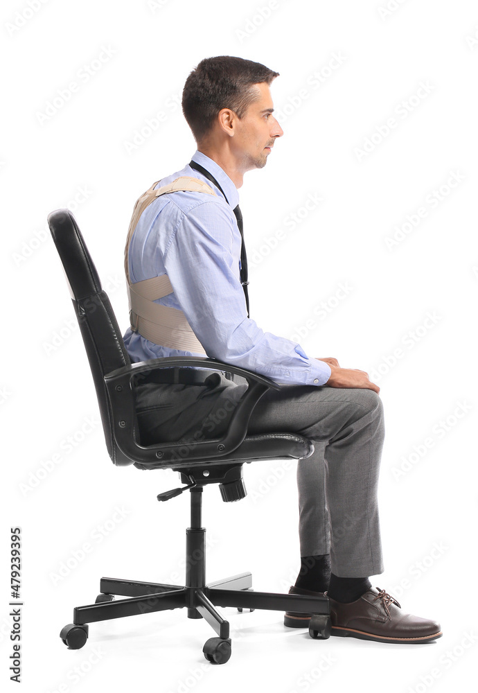 Businessman in back brace sitting on chair against white background Businessman in back brace sitting on chair against white background