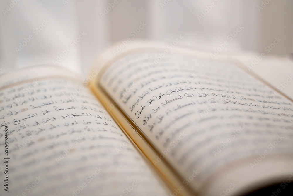 Islamic book, opened page of the quran, side view of ayah in the quran , selective focus of line Islamic book, opened page of the quran, side view of ayah in the quran , selective focus of line