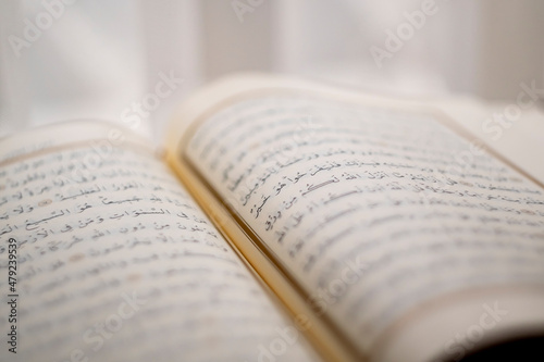 Islamic book, opened page of the quran, side view of ayah in the quran , selective focus of line