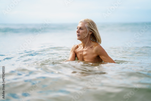 Eldery woman in good shape bathing in the sea.