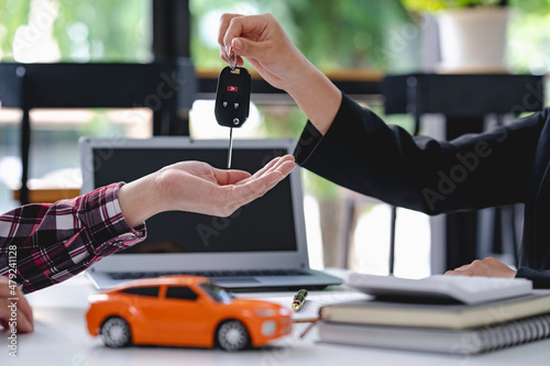 Insurance officers hand over the car keys after the tenant. have signed an auto insurance document or a lease or agreement document Buying or selling a new or used car with a car