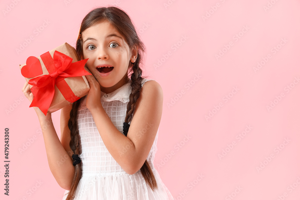Surprised little girl with gift on color background. Valentine's Day celebration Surprised little girl with gift on color background. Valentine's Day celebration