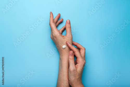 hand cream applied to hands on a blue background top view 