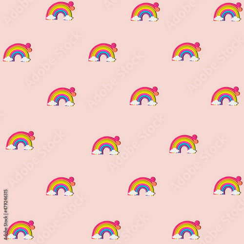 Colorful rainbow with clouds at the ends on pastel light pink background. Creative cute pattern. Minimal flat lay concept.