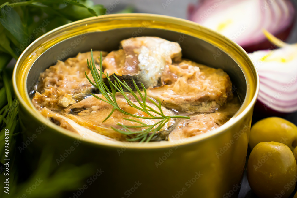 canned fish in a jar, dill on a wooden background canned fish in a jar, dill on a wooden background