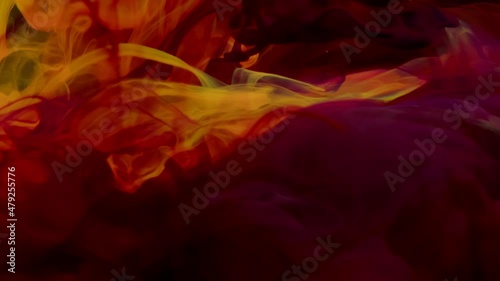 ink splash. Orange, purple and red ink splash in water on black background.