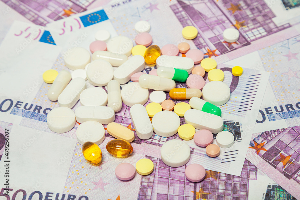 Medicine pills over euro banknotes. Covid-19 coronavirus pills are on the euro banknote. The concept of insurance medicine, insurance, high cost, high cost of drugs. Medicine pills over euro banknotes. Covid-19 coronavirus pills are on the euro banknote. The concept of insurance medicine, insurance, high cost, high cost of drugs.