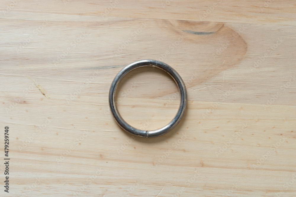 metal ring on a wooden surface - obrazy, fototapety, plakaty 