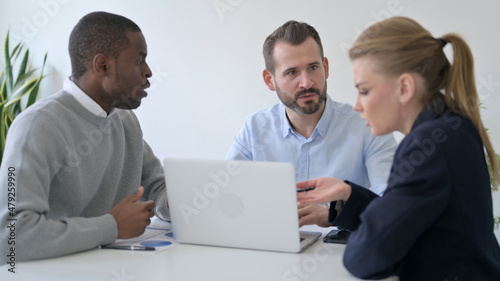 Business People Arguing while using Laptop in Office