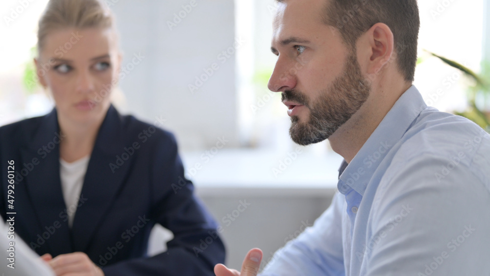 Cheerful Businessman Talking to Male and Female Colleagues Cheerful Businessman Talking to Male and Female Colleagues